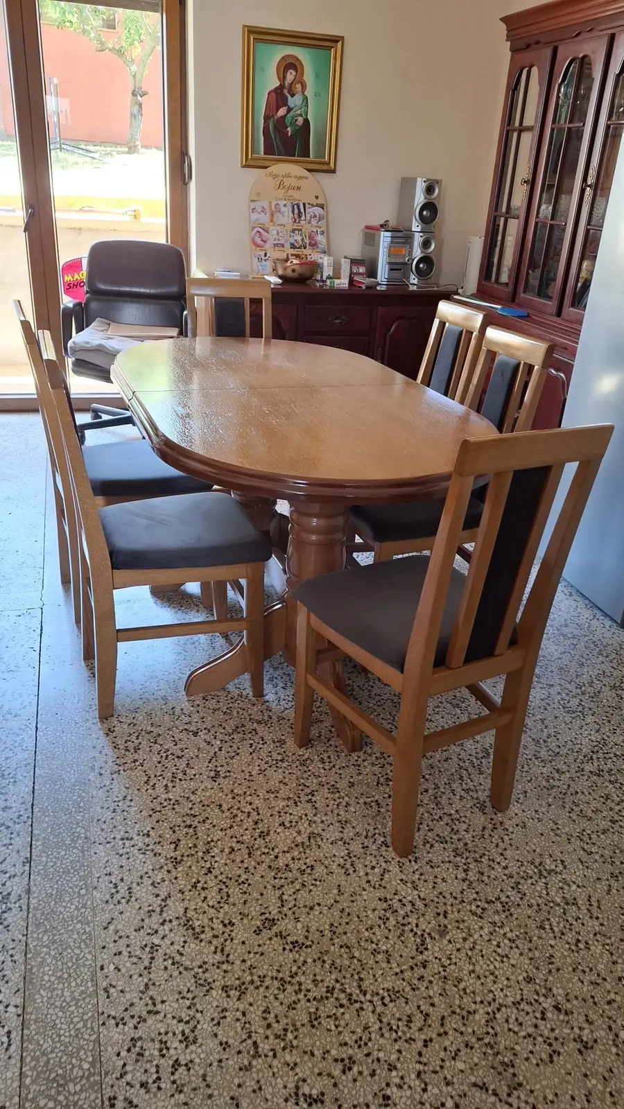 Ovalni sto od drveta sa tapaciranim stolicama