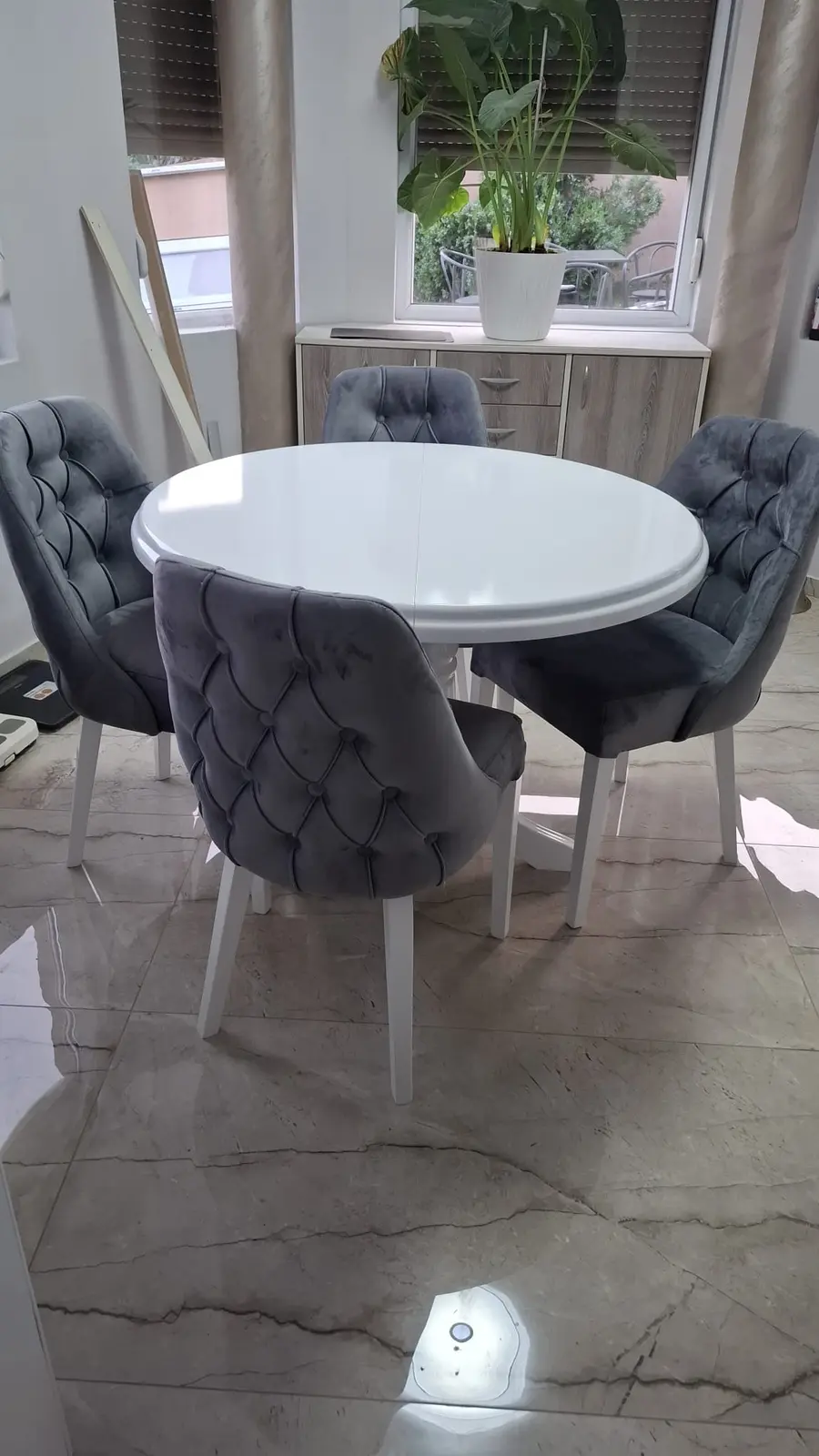 Okrugli beli sto sa sivim tapaciranim stolicama