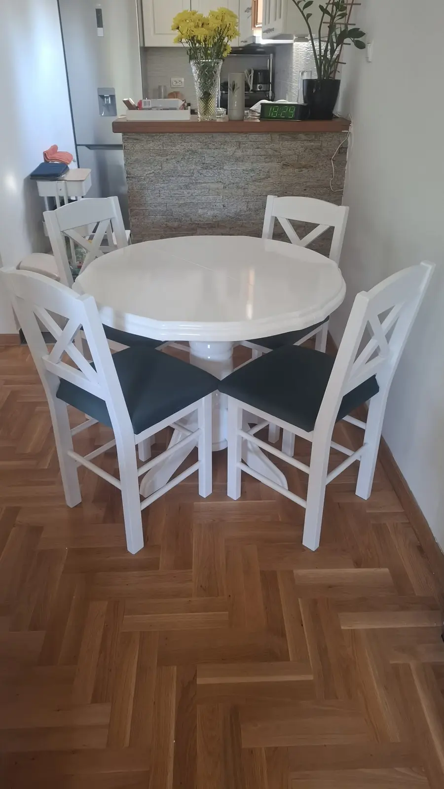 Okrugli beli sto sa četiri bele stolice