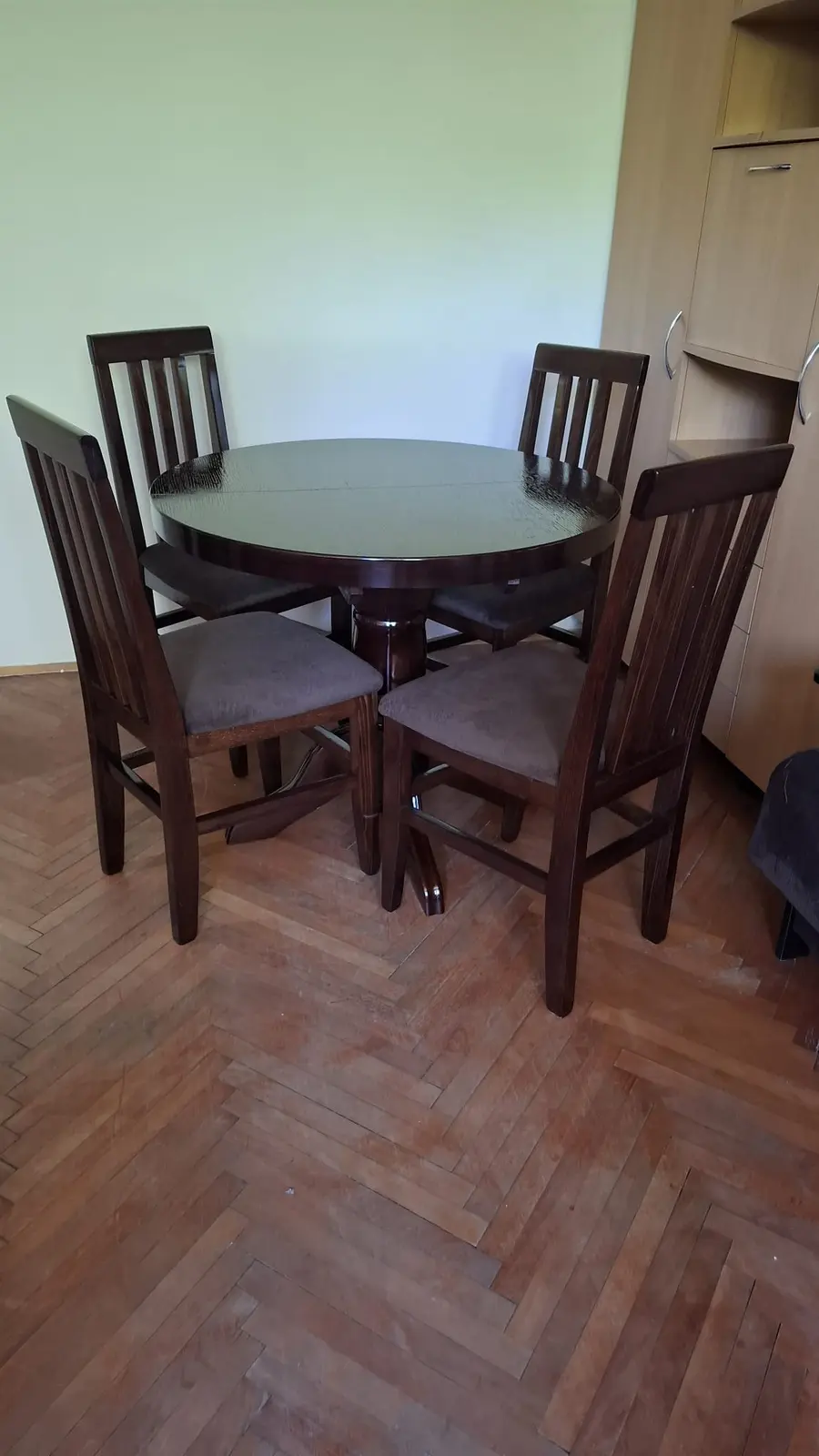 Okrugli trpezarijski sto od tamnog drveta sa četiri stolice