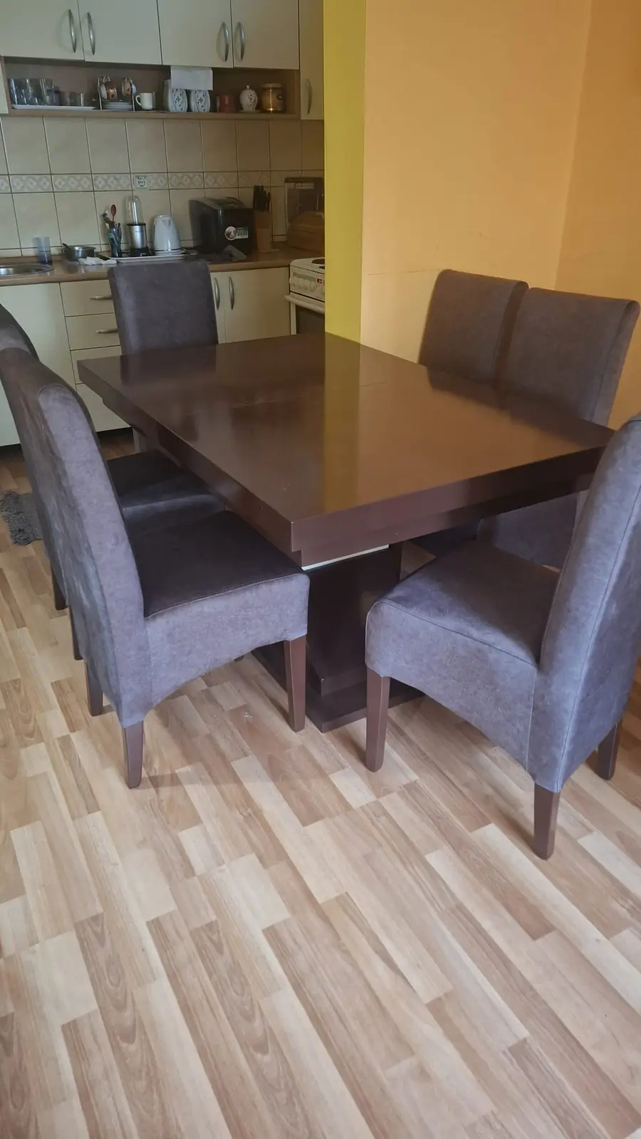 Tamni trpezarijski sto sa sivim stolicama